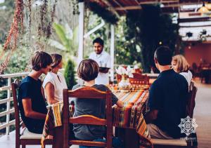 un grupo de personas sentadas alrededor de una mesa en Inti Kamari Wellness Lodge & Convention Center, en Santa Isabel