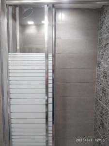 a walk in shower in a bathroom with stainless steel at Meltemi in Vourkari