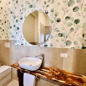 ein Bad mit einem Waschbecken und einem Spiegel in der Unterkunft Palazzo Matà Boutique Hotel in Taranto