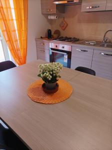 un jarrón de flores sobre una mesa en una cocina en la mia casetta, en Bisceglie