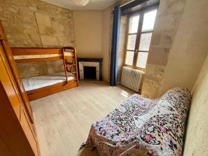 GroléjacにあるLes Althéas - Gite familial avec terrassesのベッドルーム1室(二段ベッド2台、ソファ付)