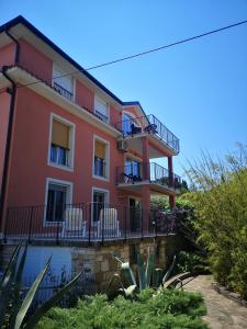 różowy budynek z krzesłami na balkonie w obiekcie Meduza&Manta w mieście Izola