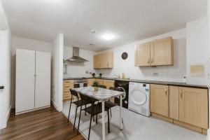 a kitchen with a table and a laundry machine at LimeHouse Double Rooms - 3 in London