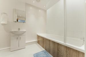 a white bathroom with a sink and a shower at LimeHouse Double Rooms - 3 in London