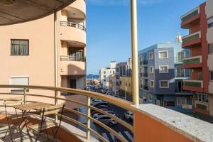a balcony with tables and chairs on a city street at El Medano cerca del mar in El Médano