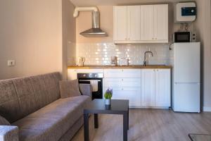 a living room with a couch and a kitchen with a refrigerator at El Medano cerca del mar in El Médano +7 photos