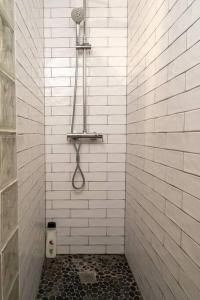 a white tiled shower with a shower head at El Medano cerca del mar in El Médano