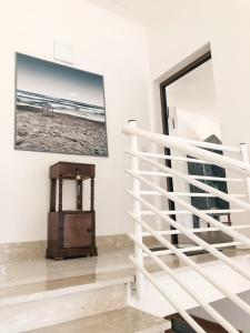 uma escada branca num quarto com uma fotografia da praia em "La casa di Ale" MODERN SUITE em Mondragone
