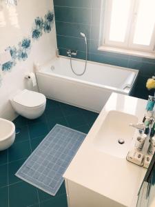 uma casa de banho com uma banheira, um WC e um lavatório. em "La casa di Ale" MODERN SUITE em Mondragone