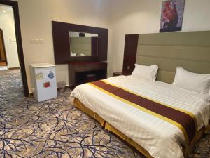 برج الذهبيه في عَفيف: غرفة الفندق بسرير كبير ومرآة