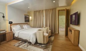 um quarto de hotel com uma cama grande e uma cadeira em C. Apartments Annex em Abuja
