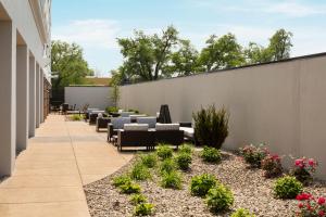 a patio with chairs and plants on a building at Courtyard Louisville Airport in Louisville