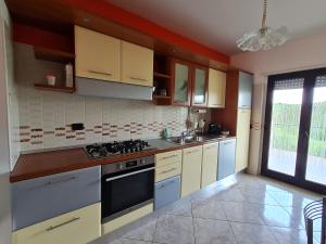 cocina con armarios blancos y fogones en Villa Emilia, en San Salvo
