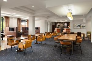 une salle à manger avec des tables et des chaises ainsi qu'une cafétéria dans l'établissement Courtyard Louisville Airport, à Louisville