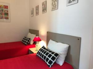 ラ・シオタにあるVILLA DU GOLFE T3 Beaurivageのベッドルーム1室(赤いシーツとランプ付きのベッド2台付)