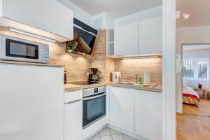 a kitchen with white cabinets and a microwave at Strandnähe! Moderne 3 Zimmer Ferienwohnung!! in Bansin +6 photos