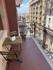 einen Balkon mit einem Tisch und einer Bank auf einem Gebäude in der Unterkunft Apulia appartament in Taranto