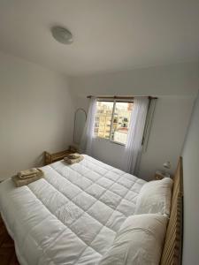 a bedroom with a large white bed with a window at Hermoso con la mejor ubicación in Buenos Aires