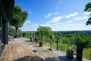 a wooden deck with a view of the forest at Les Monts d'Amara, ressourcement, nature, santé in Campuac +60 photos