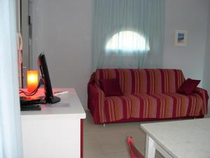 a living room with a couch and a computer on a desk at Pergola n.3 in Cavo