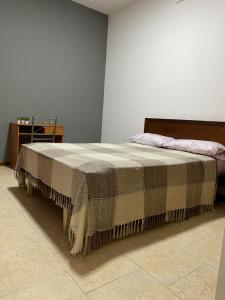 Una cama con una manta en una habitación en Excelente y amplio dpto 3 dormitorios c cochera privada en Mendoza