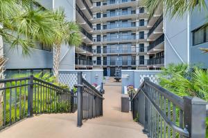 une passerelle devant un bâtiment planté de palmiers dans l'établissement Myrtle Beach Resort Condo Walk to Family Kingdom!, à Myrtle Beach