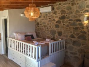 a room with a crib and a stone wall at Palma resorts in Nikiá