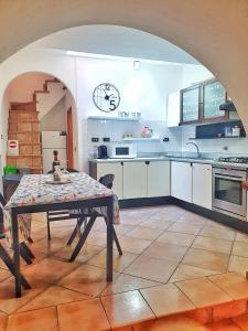 a kitchen with a table in the middle of a room at Ubetty village center two-bedrooms apartment 5terreparco in Riomaggiore