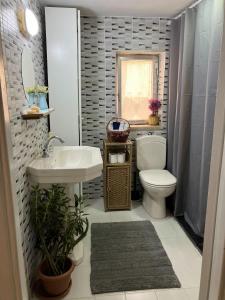 a bathroom with a white toilet and a sink at Darna Hostel in Amman