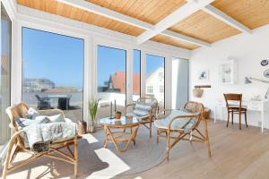 a living room with a table and chairs and windows at Søndergade 8, 1 Sal in Løkken