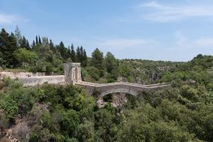 un puente al lado de una montaña con árboles en Nina Home - Selfcheck-in, en Canicattini Bagni