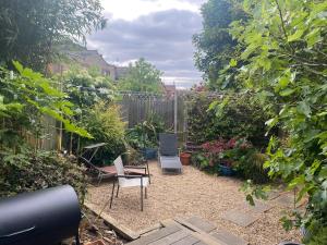 a garden with chairs and plants and a fence at Tranquil Garden View Double Room in London