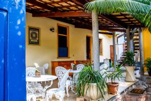 レンソイスにあるPousada Solar Azulの白いテーブルと椅子、植物のあるパティオ