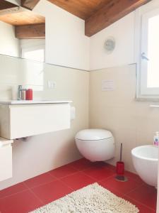 uma casa de banho com um WC branco e um lavatório. em "La casa di Ale" MODERN SUITE em Mondragone