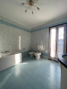 a bathroom with a tub and a toilet and a sink at Villa Hoara in Gorizia