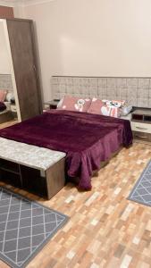 um quarto com uma cama grande e um cobertor roxo em مدينتي em Madinaty