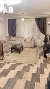 uma sala de estar com um sofá e uma mesa de centro em مدينتي em Madinaty