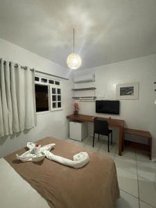 a bedroom with a bed and a desk and a television at Pousada Mananauê Beach in Porto De Galinhas +73 photos