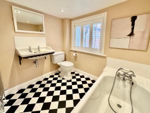 a bathroom with a black and white checkered floor at Laurel Cottage Sandsend in Sandsend +40 photos
