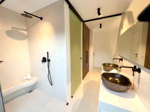 a bathroom with two sinks and a tub at New Serenity Art Villa Elounda in Elounda