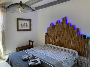 een slaapkamer met een bed met een houten hoofdeinde bij Gite Domaine Des Pierres Blanches in Belmontet