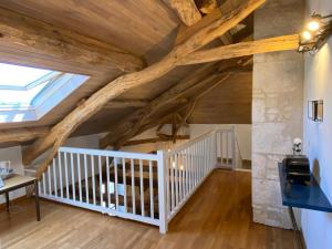 een kamer met houten plafonds en een trap met een dakraam bij Gite Domaine Des Pierres Blanches in Belmontet