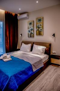 a bedroom with a bed and two paintings on the wall at Diamond Suites 32 in Thessaloniki