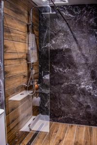 a glass shower in a bathroom with wooden walls at Diamond Suites 32 in Thessaloniki