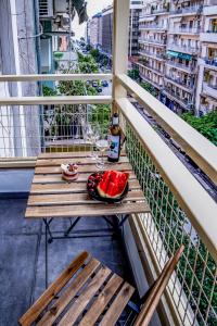 a table on a balcony with a plate of watermelon at Diamond Suites 32 in Thessaloniki
