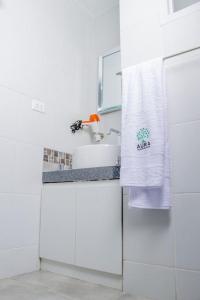 Baño blanco con lavabo y toalla en Departamento Amoblado en Lima