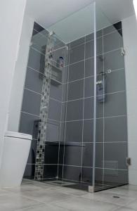 y baño con ducha de cristal y aseo. en Departamento Amoblado, en Lima