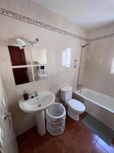 a bathroom with a sink and a toilet and a tub at Casa de Fernando in Puerto Real