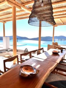 drewniany stół w pokoju z widokiem na ocean w obiekcie New Serenity Art Villa Elounda w Elundzie