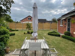 un paraguas blanco sentado en un banco en un patio en The Hideaway en Stratford-upon-Avon